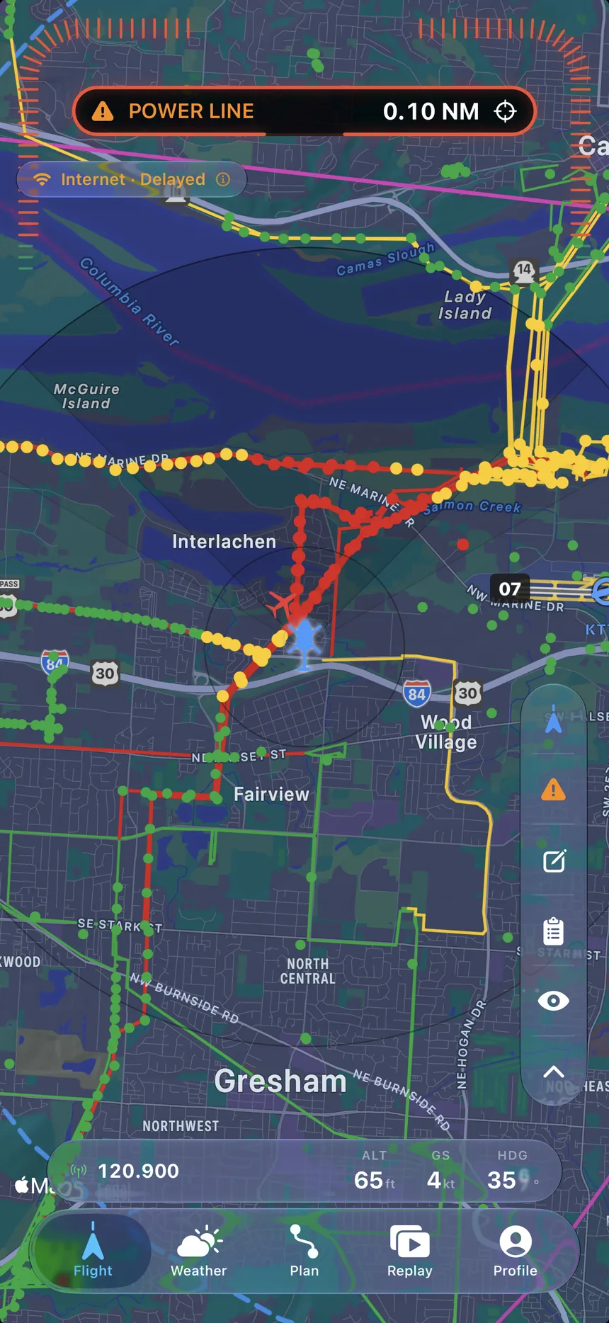The Lateral moving map: a dark chart dense with colour-coded obstacle and power-line spans.